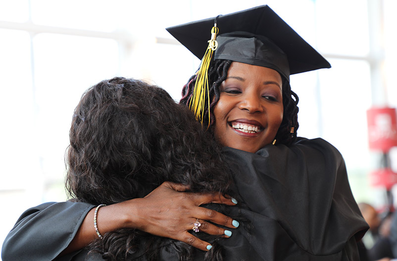graduating students hugging in joy