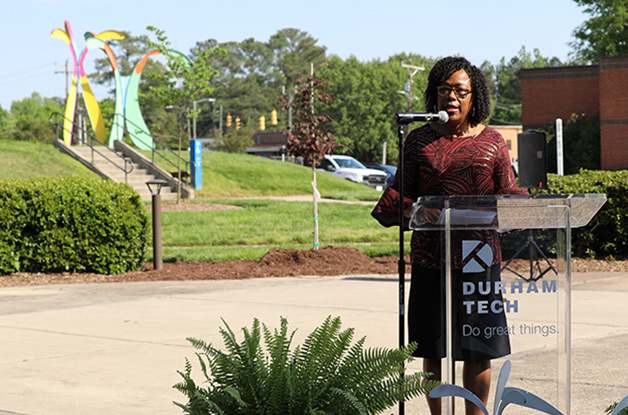 A speaker at a podium introduces a new piece of artwork