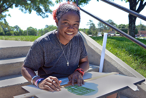 scholarship student sitting on outdoor steps on campus