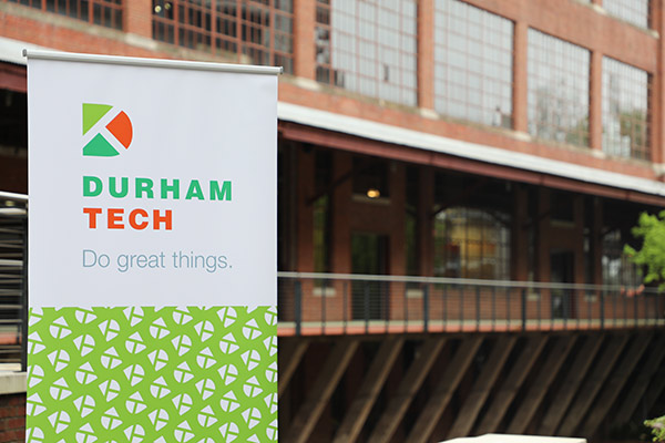 Brick Warehouse building with a Durham Tech banner in front saying Do Great Things