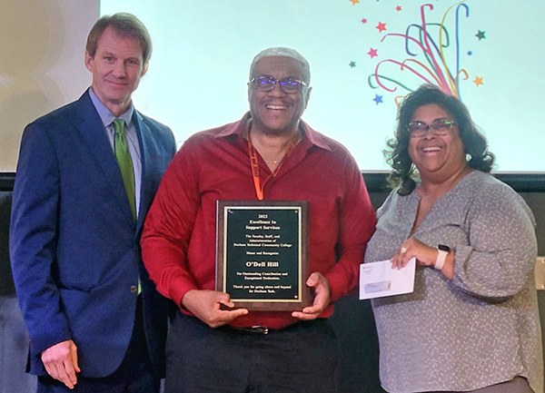 President Buxton, recipient O'Dell Hill, and Angela Davis pose with plaque