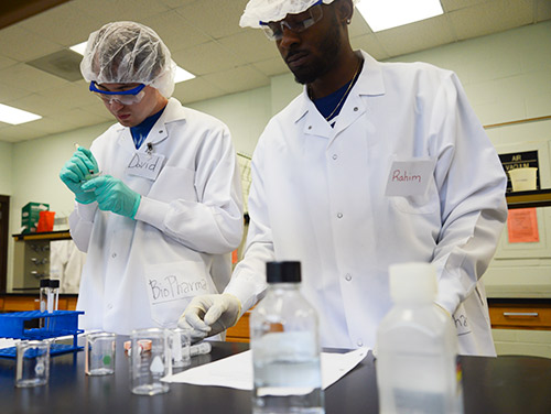 students in a chemistry lab wearing lab coats 