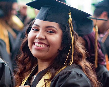smiling student in her graduation regalia