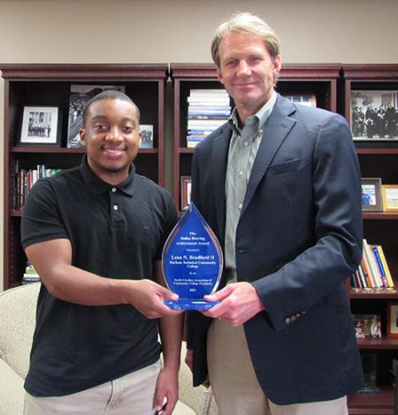 Leon Bradford with President Buxton holding the teardrop shaped glass Dallas Herring award