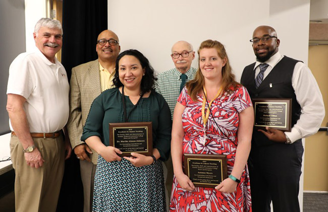 award recipients holding plaques pose with President Ingram