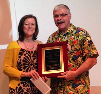 Karen McPhaul, holding plaque, poses with President Ingram