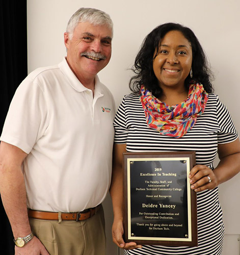 Diedre holds her award proudly while posing with President Ingram