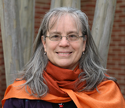 Mary Grace poses in front of a brick building