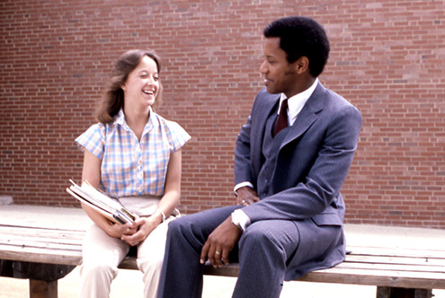 Historical photo of third president Dr. Phail Wynn talking with a student