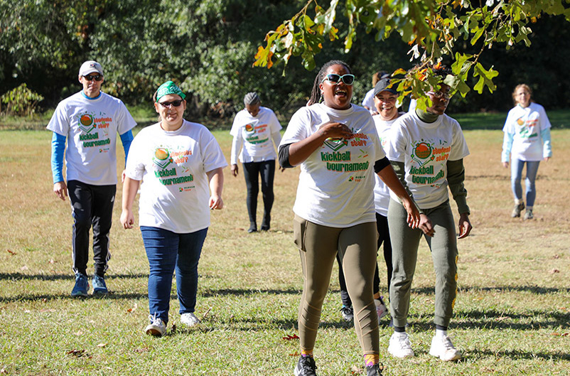 employees walk off a field after a kickball tournament