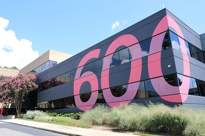 modern two-story building with a large 600 painted on it in a bright pink and violet