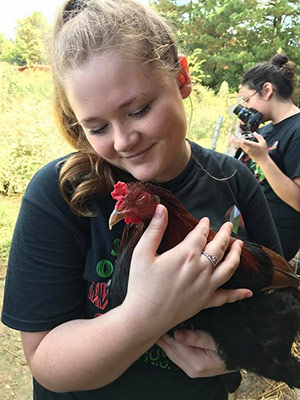 student holding a chicken in her arms