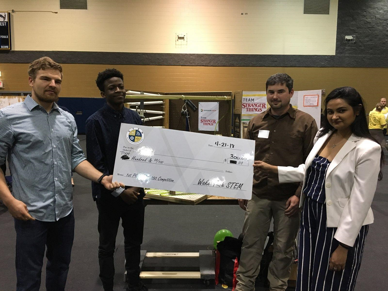 group of engineering students holding large check