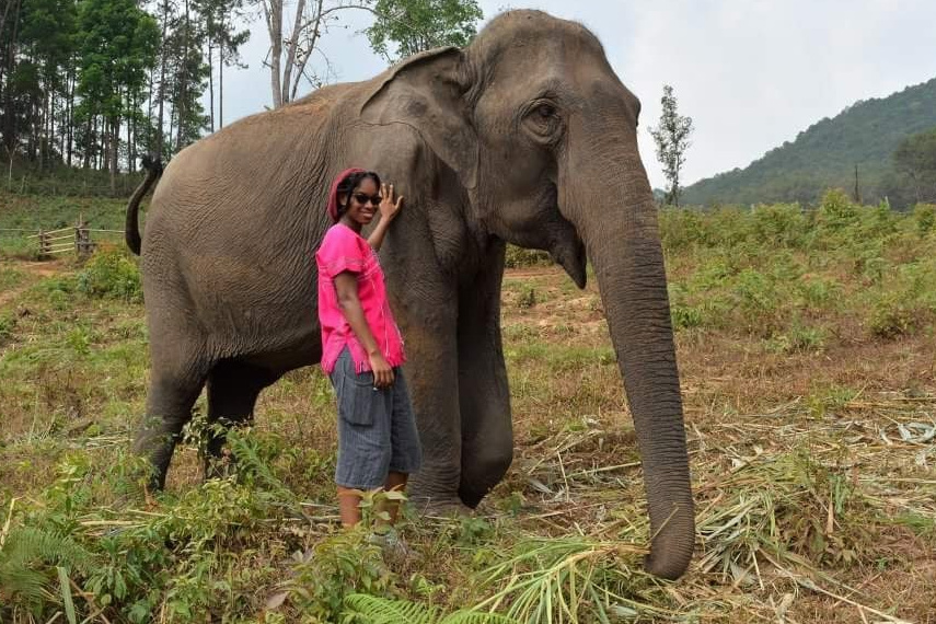 Jonitka standing in front of elephant in field