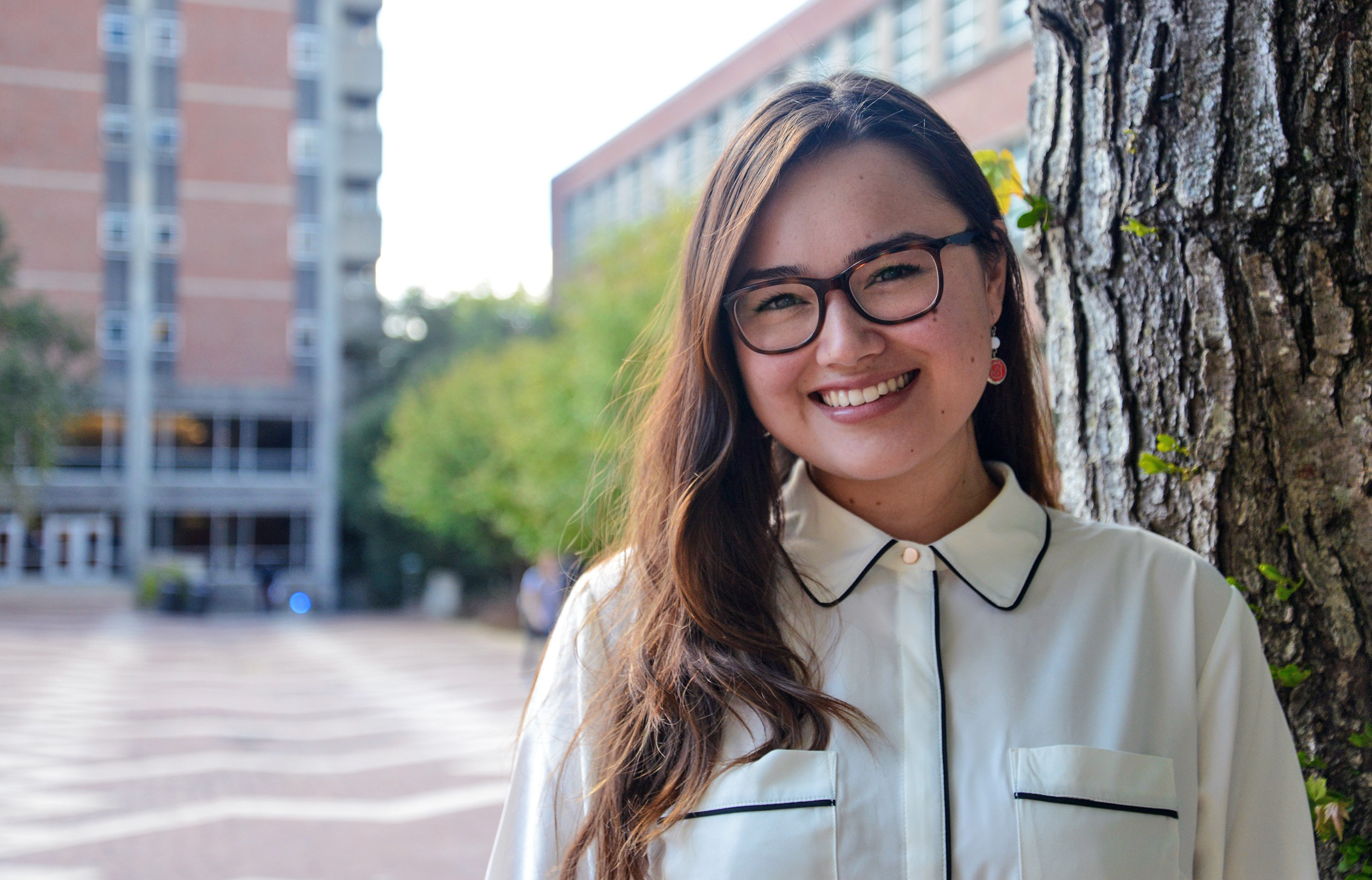 headshot of Madeline on NC State's campus, standing in front of a tree