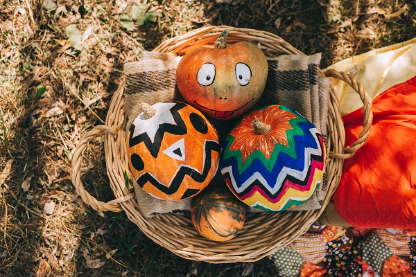 three painted pumpkins in a basket