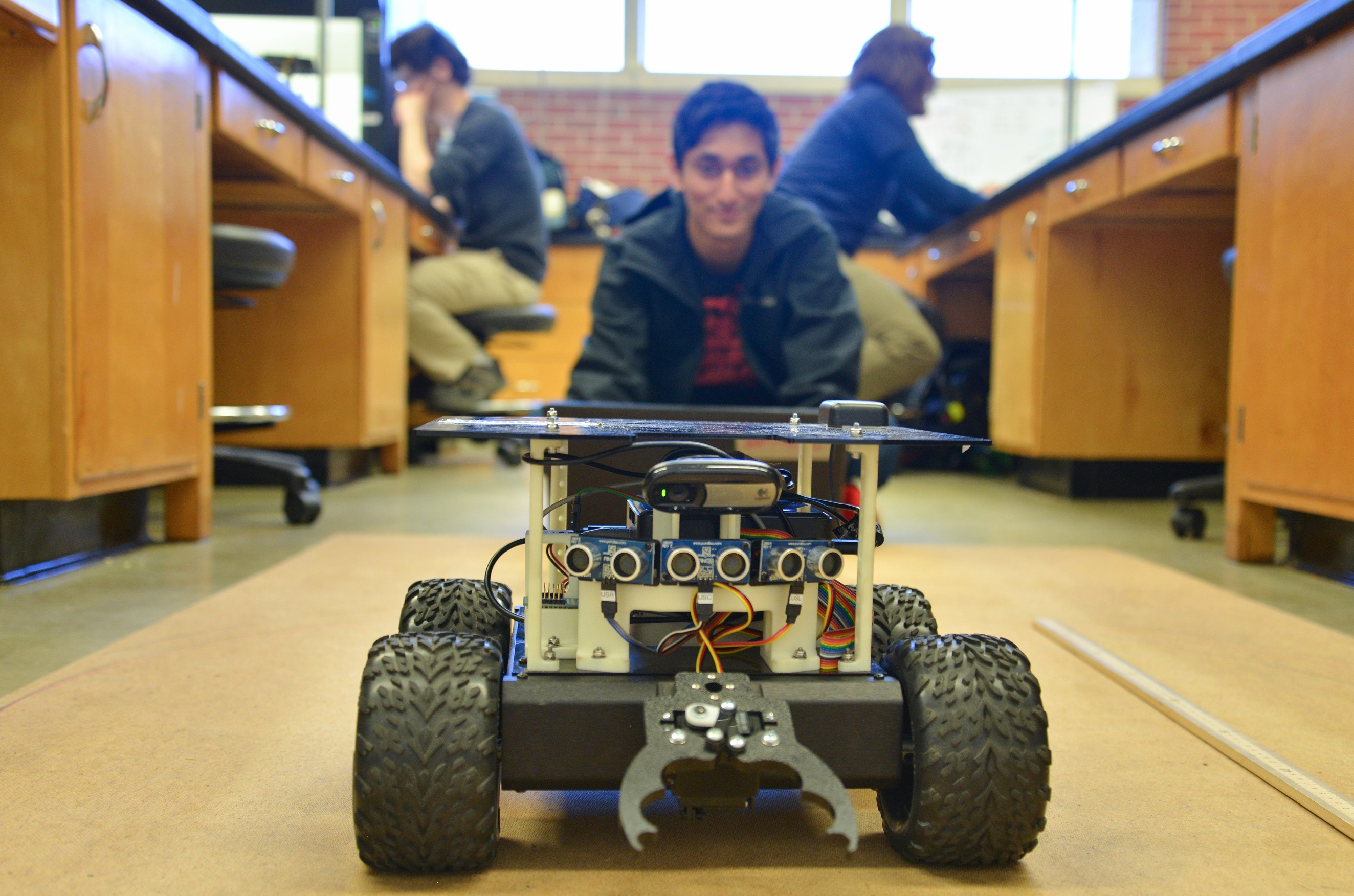 close up of rover and student sitting behind it smiling