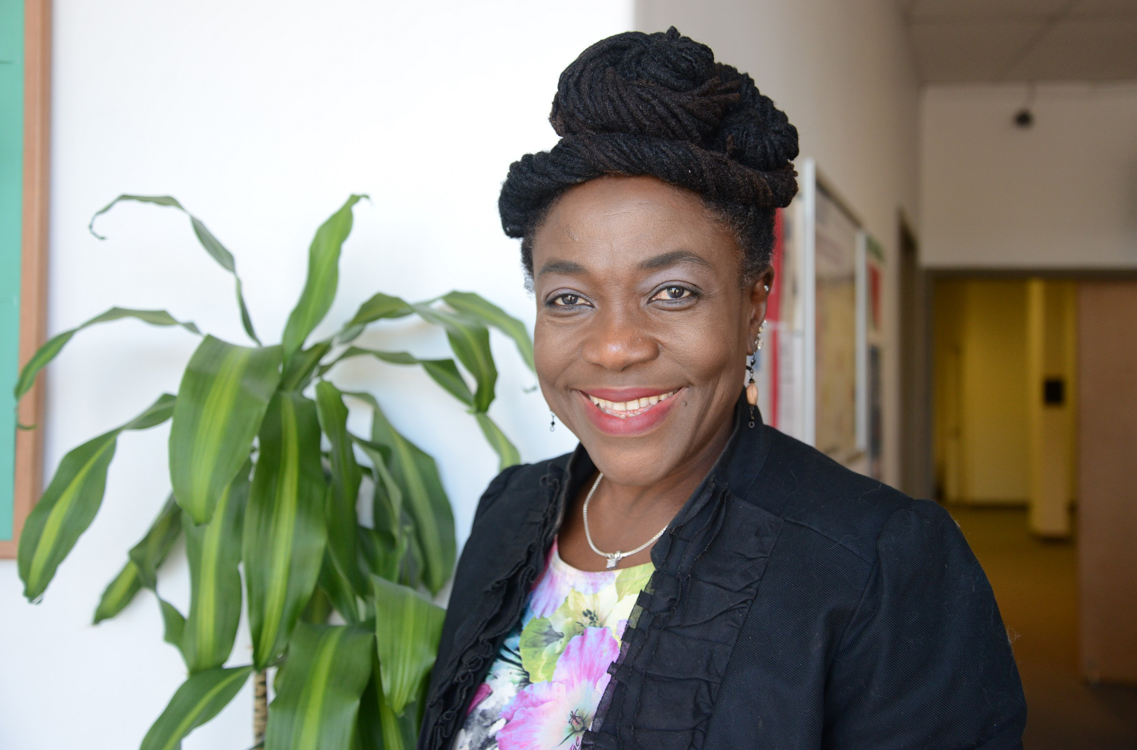 headshot of valerie in her office foyer with plant behind her