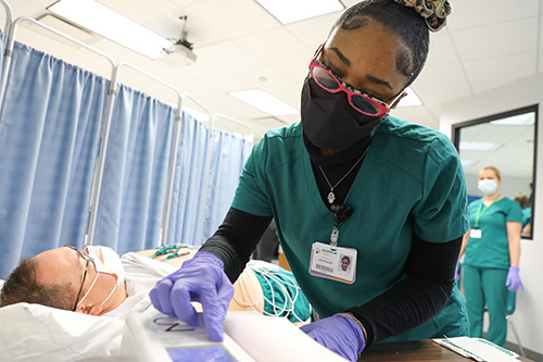 EKG student practices how to view the EKG monitor in lab