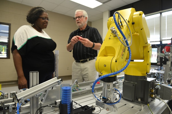 Patrick Wynn discusses the LR Mate 200iD robotic arm with a student