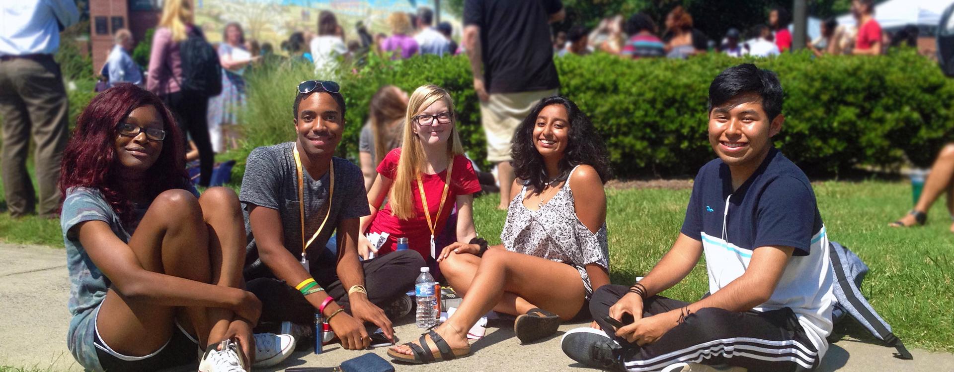 Diverse group of students sitting together on the campus lawn
