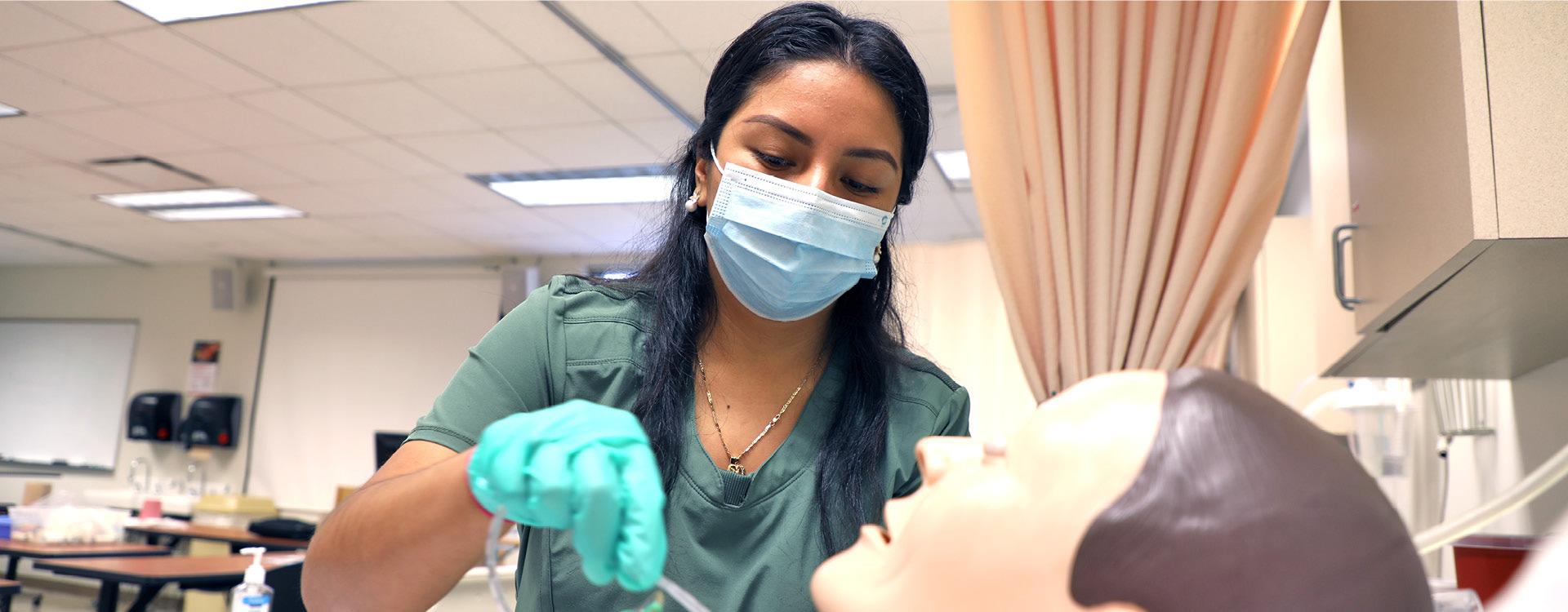 respiratory therapy student wears hospital mask while in a clinical lab class