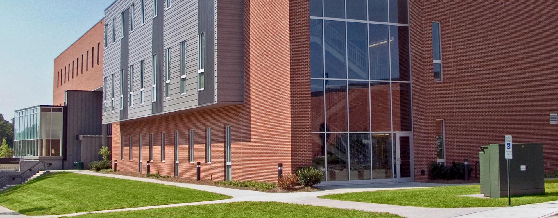brick, gray panel, and glass campus building