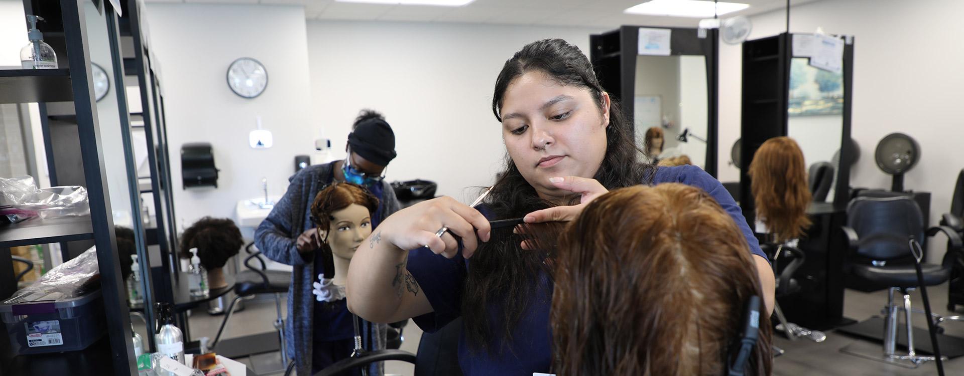 cosmetology students practice cutting hair on dummies in a hair studio