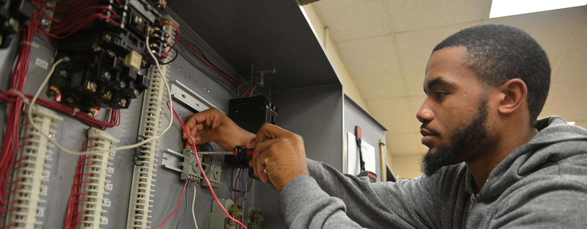 student works on electrical circuitry in lab