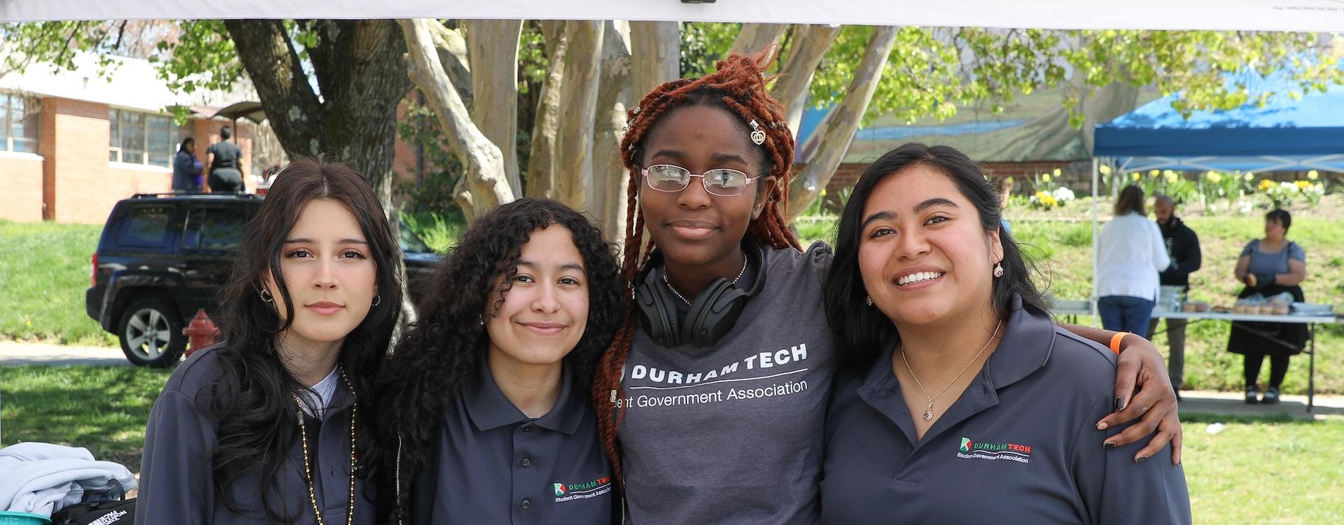 This image features four members of the Student Government Association standing outside smiling. They are outside during a Durham Tech Spring Fling event.