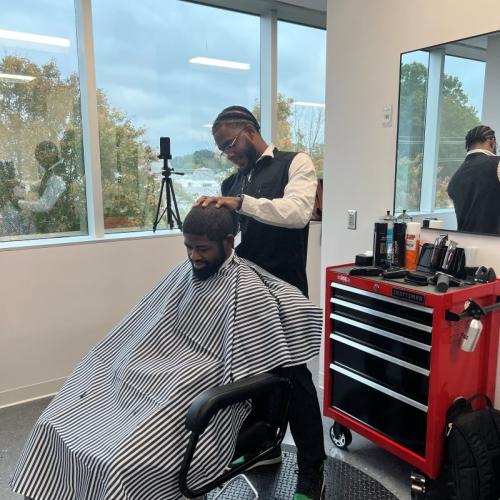 A Durham Tech Barbering student giving a haircut to a client
