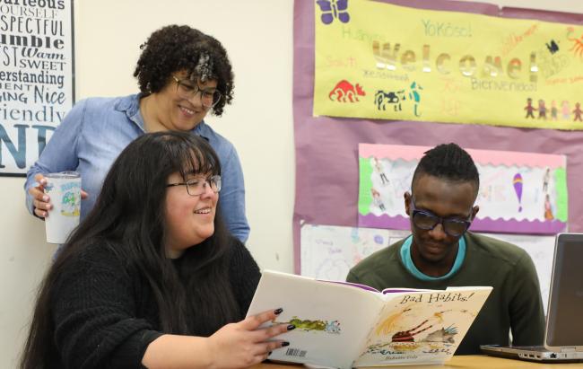 Students reading a children's story in a classroom teaching Early Childhood Education