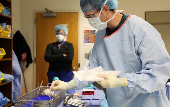 student preparing sterilized equipment for a surgical operation