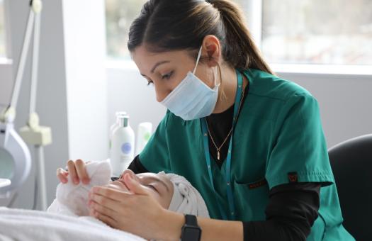 Esthetics student massage a client's face during a an appointment