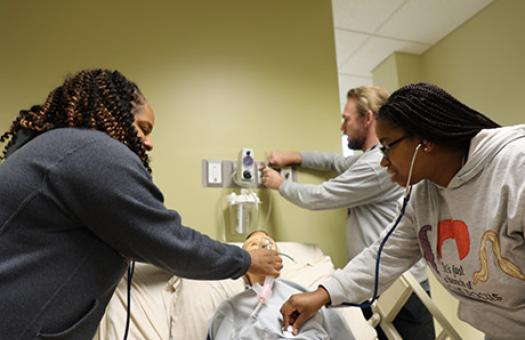 respiratory students practice patient care in a health lab setting