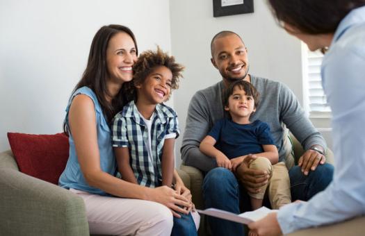 family sitting and talking with a social services professional