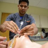 student practicing intubating a mannequin