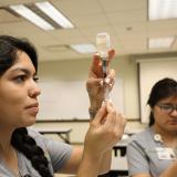 students practicing drawing a syringe from a medicine vial