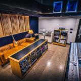 Audio recording room with soundboards, a lounge area, and an electric guitar.