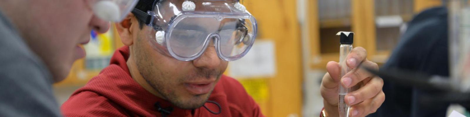 student wearing goggles performing chemistry experiment