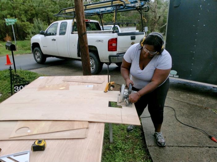 person using tablesaw with headphones and goggles